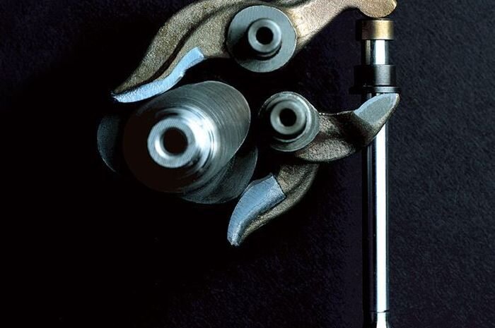    Распредвал (слева), два коромысла и клапан - основные детали десмодромного механизма газораспределения.Otomotifnet.com