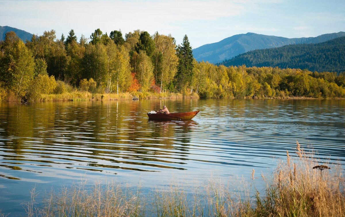 Реках озерах начинается. Рыбалка на озере. Таежное озеро. Лодка в Сибири на реке. Рыбак в лодке на озере.