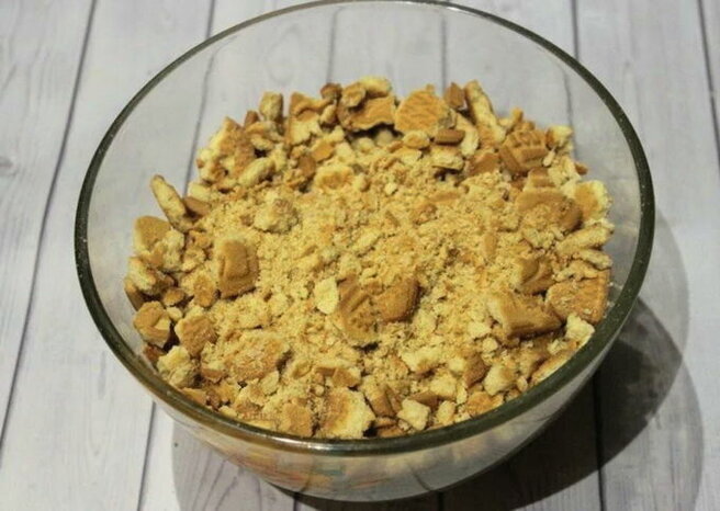 Подготовим печенье – его необходимо измельчить в крупную крошку. Сделать это можно блендером или с помощью пакета и скалки. 
