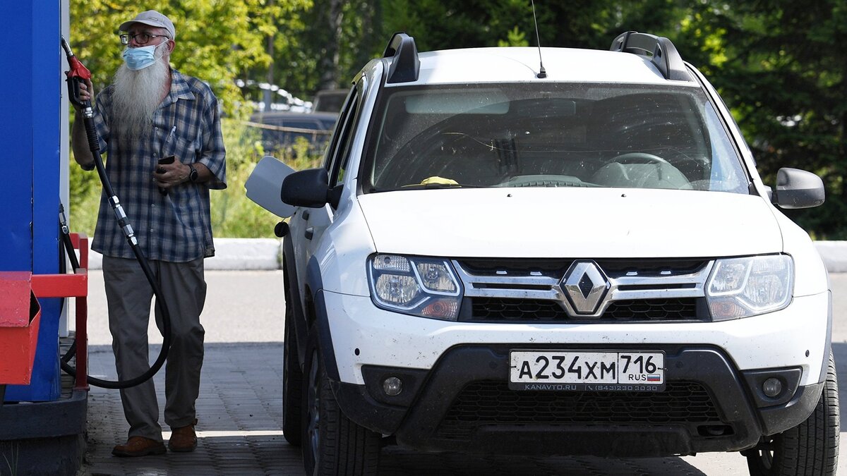    Мужчина заправляет автомобиль.© РИА Новости . Максим Богодвид