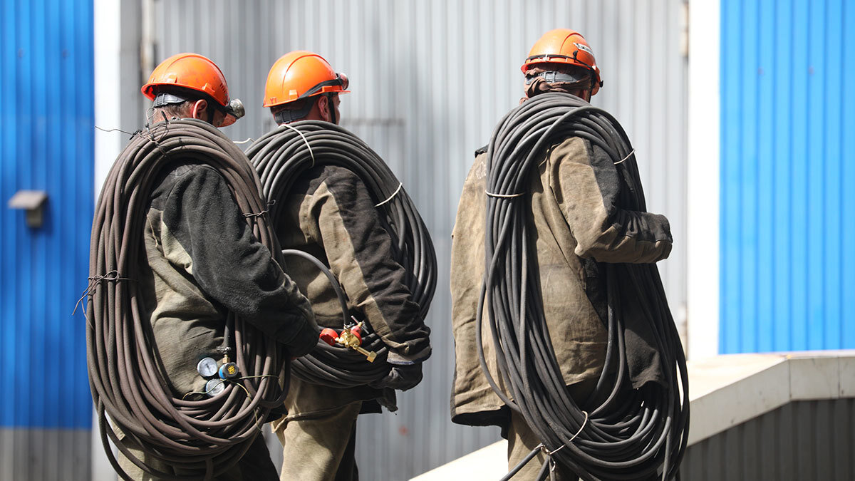 Двое рабочих фото. Два строителя. Гастарбайтеры на стройке. Рабочий в каске. Профессиональная бригада строителей.
