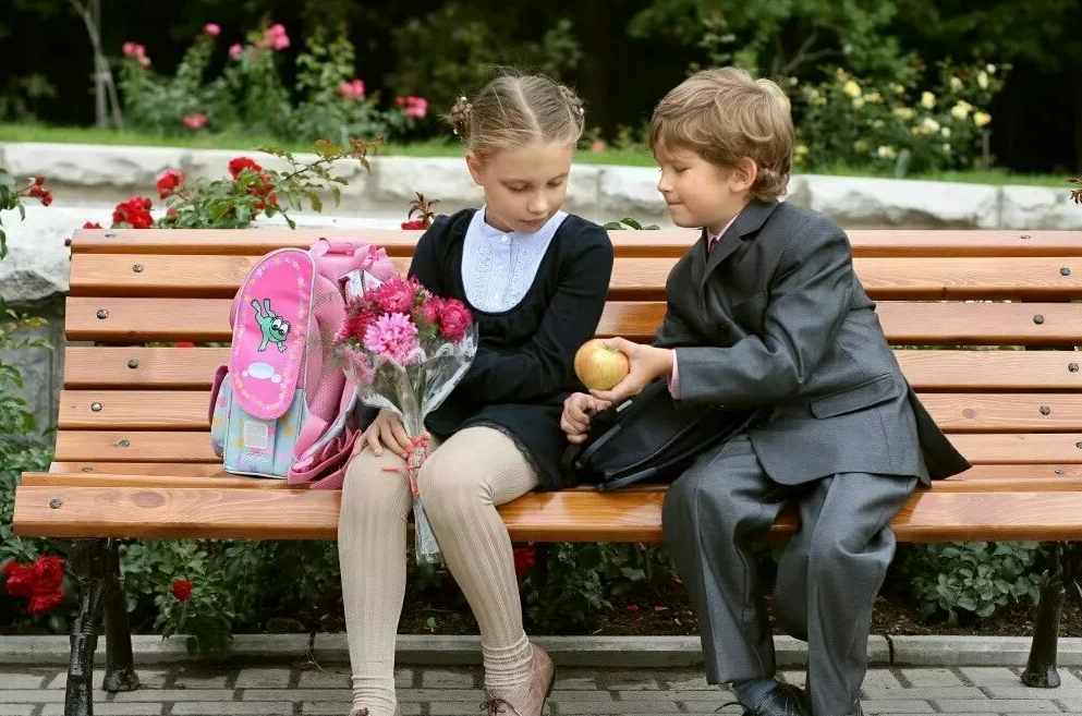 Школьная любовь. Мальчик и девочка школьники. Любовь школьников. Дети на скамейке.