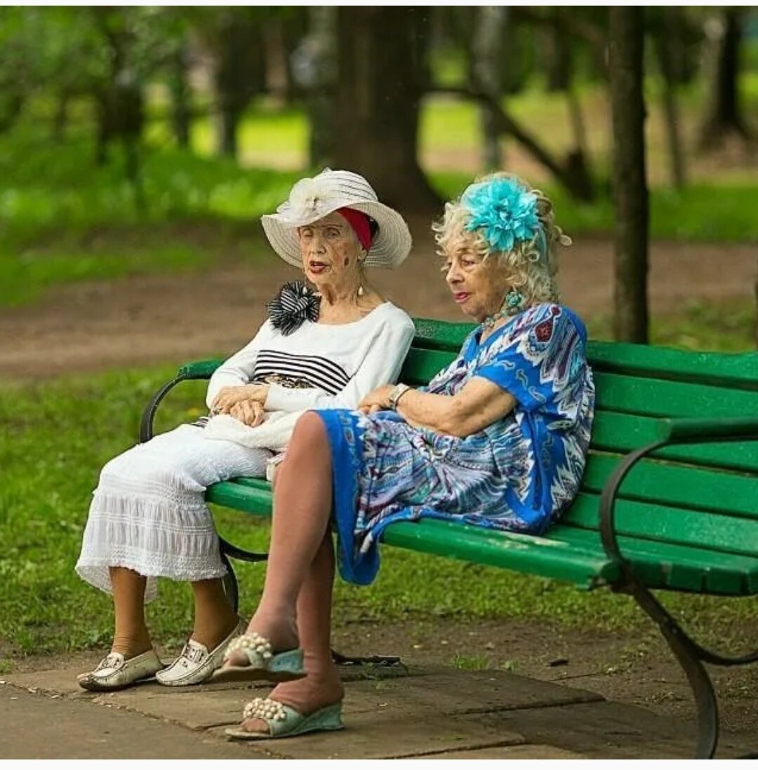 бабушка сидит на скамейке и машет ногами