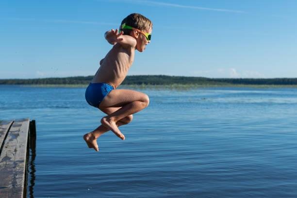 Мальчик прыгает в воду