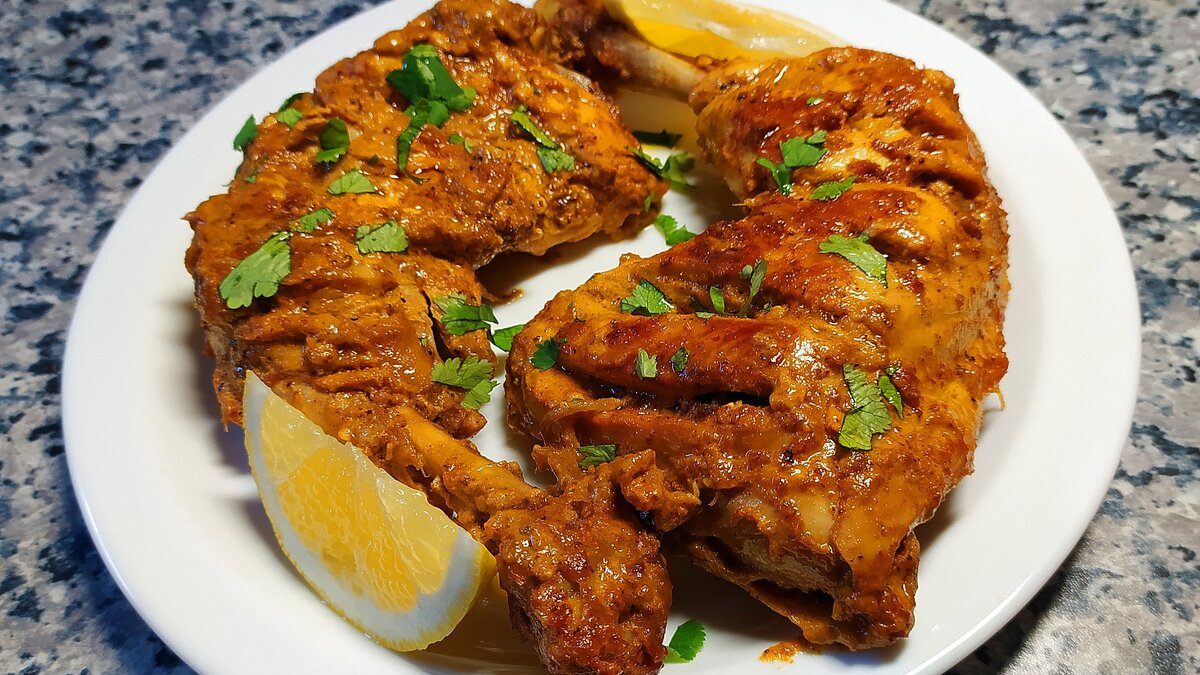 Курица Тандури - традиционное индийское блюдо, невероятно вкусное, сочное и сытное блюдо.  
Ингредиенты:
куриные окорочка - 3 шт.
лимонный сок - 4 ст.л.
перец чили - 1 ч.л.
паприка - 1 ч.л.
куркума - 0.5 ч.л.
кориандр молотый - 1 ч.л.
зира молотая - 1 ч.л.
гарам масала (смесь специй) - 0.5 ч.л.
соль и черный перец по вкусу
чеснок - 3 зубчика
имбирь - 30 гр.
йогурт или кефир - 80 мл.
масло сливочное и растительное для жарки 
уголь березовый, фольга

1. Окорочка промыть и обсушить бумажным полотенцем. Срезать кожу и всё ненужное. С двух сторон сделать неглубокие разрезы.
2. В посуду с окорочками добавить лимонный сок, перец чили, паприку, куркуму, молотый кориандр, молотую зиру, смесь специй гарам масала, соль, черный перец, натертые на мелкой терке чеснок с имбирем и йогурт. Все тщательно перемешать и оставить мариноваться на 2-3 часа.
3. В сковороде разогреть растительное и сливочное масло. Обжарить в нем на среднем огне замаринованные окорочка, переворачивая каждые 2-3 минуты. После появления золотистой корочки убавить огонь на минимум, смазать окорочка поочередно оставшимся маринадом, Закрыть крышкой и готовить 10-12 минут с каждой стороны.
4. Приготовить уголь и сделать блюдце из фольги. Разогреть уголь можно на плите до красноты. В сковороду между окорочков установить блюдце из фольги, положить туда разогретый уголь и сверху на уголь влить 1 ст.л. растопленного сливочного масла. Быстро закрыть крышкой и оставить пропитываться дымком на 5-7 минут.
При подаче украсить рубленной кинзой и лимоном.