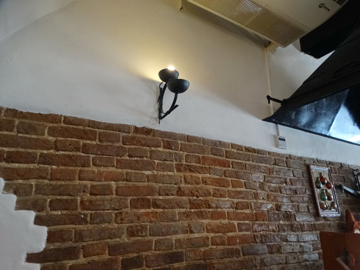 Этот кирпич - не декорация. Это не покрытый штукатуркой кусок стены здания конца XIX века. Листайте галерею. Там есть ещё фото