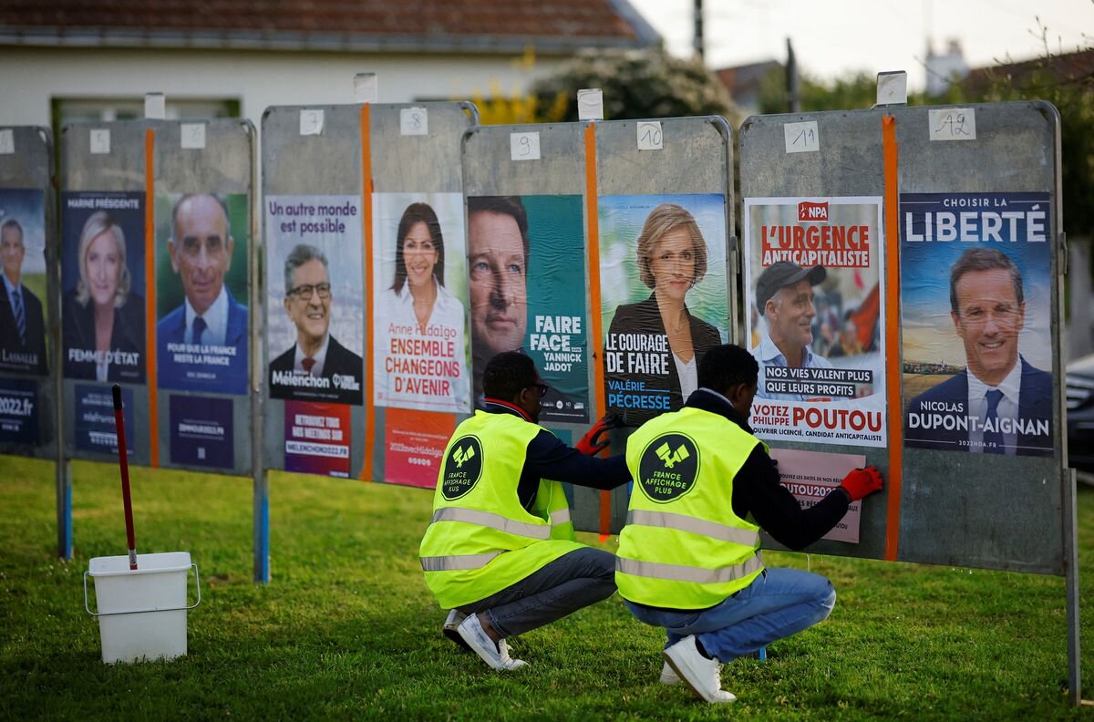 Работники France Affichage Plus клеят официальные постеры президентской кампании на места для рекламы выборов недалеко от города Нэнт, Франция. 28 марта 2022 года. Фото: Reuters/Stephane Mahe