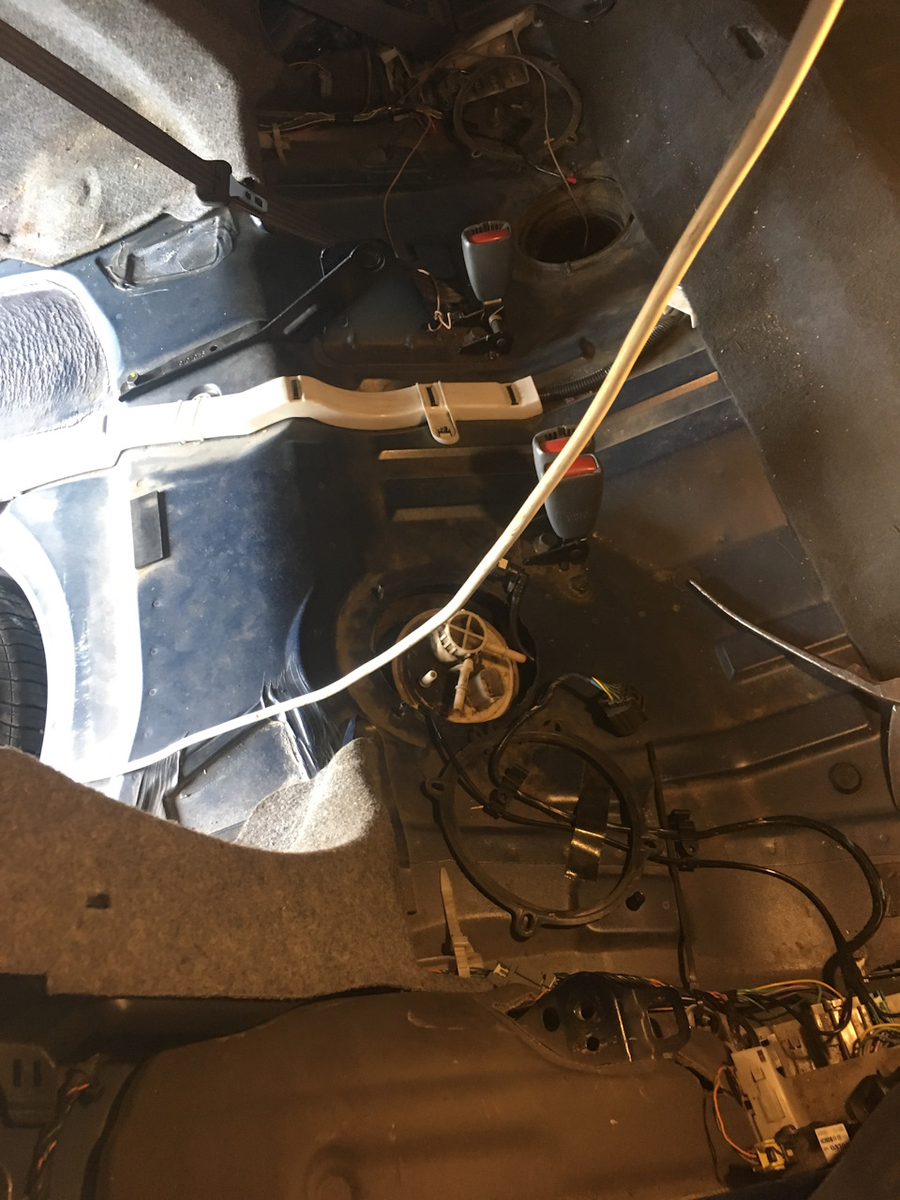 Открытое отверстие - корпус ижектора с уже заранее привязанной веревочкой, белая колба во втором отверстии - корпус бензонасоса, который я буду менять .