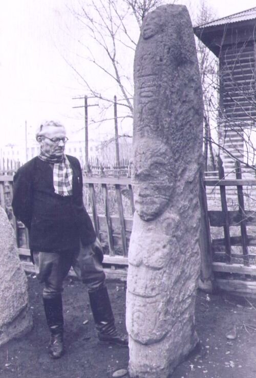 Альберт Липский стоит рядом с окуневской стелой конца III-начала II тыс. до н.э.