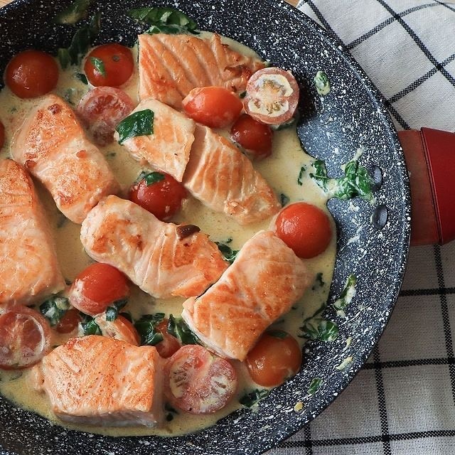Вкусная красная рыбка.   
Ингредиенты: 
-400г филе лосося 
-1 зуб. чеснока 
-10шт черри 
-50г шпината 
-100мл сливок (у меня 20%) 
-Соль 
-Оливковое и сливочное масло для жарки 
 
Приготовление: 
Рыбу нарезаем средними кусочками, я специально взяла кусочек филе поближе к хвостовой части, чтобы не было косточек 
Обжариваем на разогретой сковороде на оливковом масле до золотистой корочки с обеих сторон (примерно по 4 минуты) и снимаем с огня 
Чеснок мелко нарезаем, черри режем пополам, шпинат тоже мелко режем 
Растапливаем сливочное масло и добавляем к нему чеснок, обжариваем до золотистого цвета и добавляем черри и шпинат 
Обжариваем овощи пару минут, после чего добавляем сливки и соль по вкусу 
Добавляем в соус обжаренный лосось и Тушим буквально 1-2 минуты 
Получается невероятная вкуснота 
Приятного аппетита!