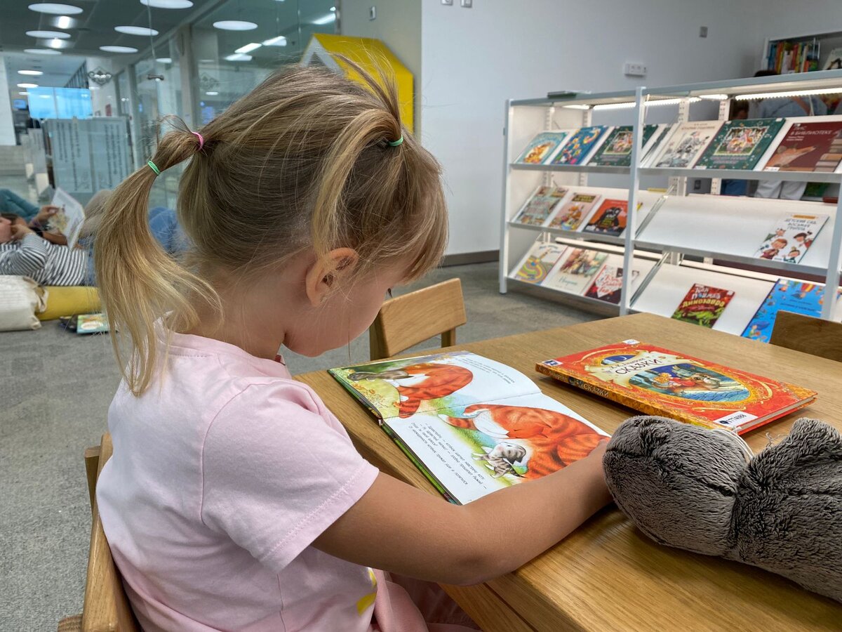 Я эту книгу даже не сфотографировала, но ниже покажу скрины обложки. А это Катя в библиотеке, читает:)