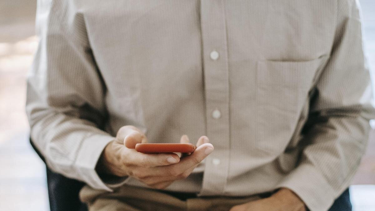    Мужчина держит в руках телефон:pexels.com