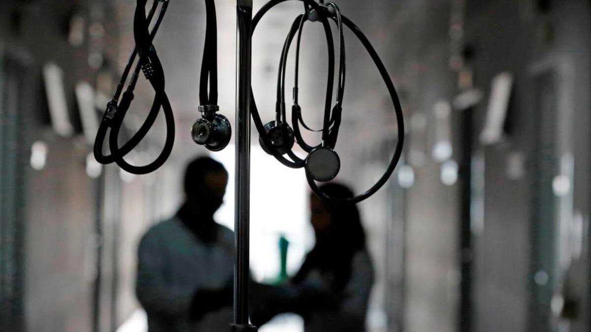    Два человека стоят в коридоре больницы:Pascal Deloche/Godong/Universal Images Group/Getty Images