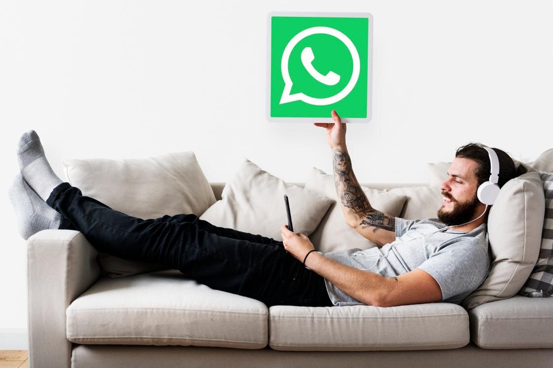    Человек на диване с логотипом WhatsApp:Freepik