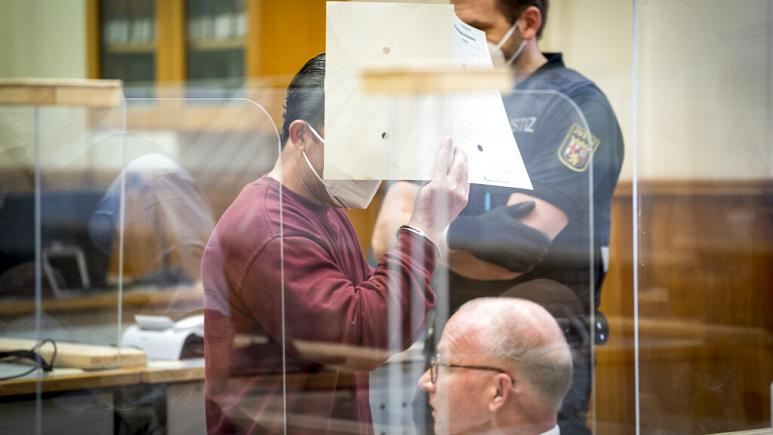 Сирийский подсудимый Эйяд аль-Гариб прячет лицо, прибыв на слушание приговора в зале суда в Кобленце, Германия, в среду, 24 февраля 2021 г.