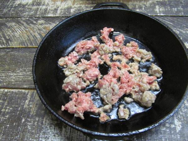 В  первую очередь приготовьте начинку. Нагрейте сковороду с ложкой  растительного масла и забросьте фарш. Жарьте его на  сильном огне, перемешивая вилкой и разделяя комки. В конце  приготовления, посолите и поперчите. Заранее замаринуйте лук или  используйте свежий красный, белый салатный или зеленый. Нарежьте  небольшими кусочками плотный помидор. Сыр натрите на мелкой терке.  Нарежьте зелень, какая у вас имеется. У меня - петрушка.