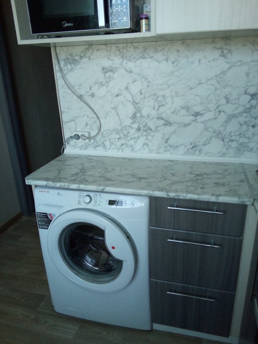 Фото встроенной в кухонный гарнитур стиральной машины у дочери.