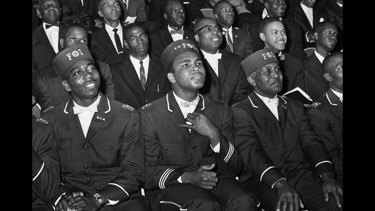 Кассиус Клей слушает выступление лидера «Нации ислама» Элайджи Мухаммада. Именно он дал боксеру новое имя, под которым тот стал известен всему миру