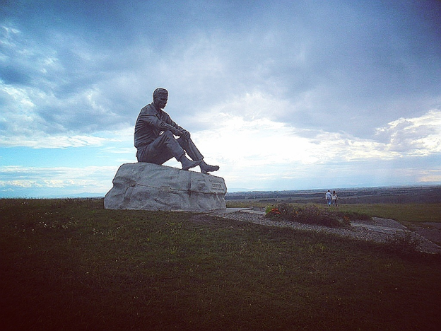 Еще не доезжая до села, мы увидели величественную фигуру писателя. Ее и памятником назвать сложно — просто человек уютно расположился на своем любимом месте. 