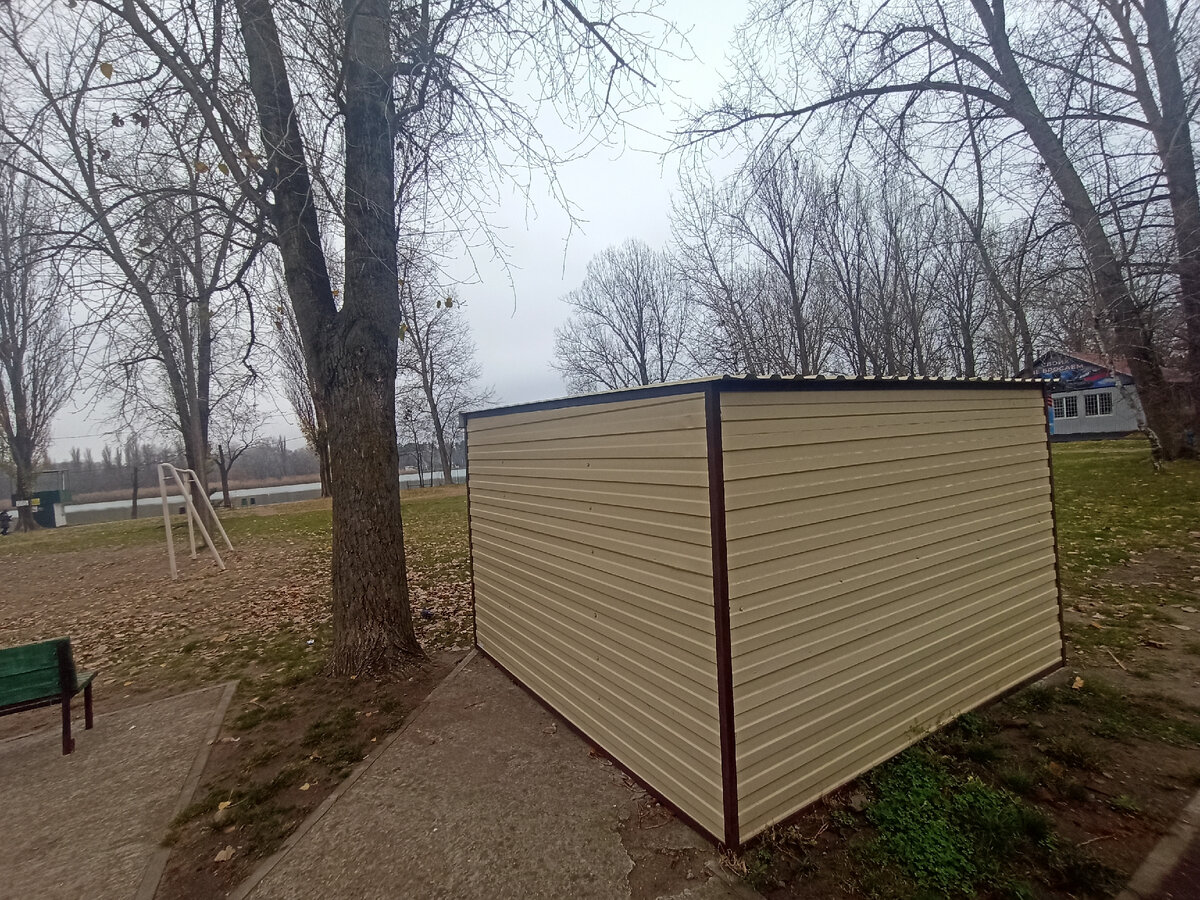 Одинокий маленький гараж в осеннем парке