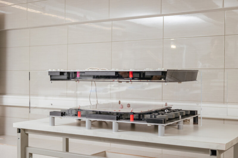    Прототип представляет собой две коробочки небольшого размера. Одну надо устанавливать на днище электромобиля, вторую — зарывать в парковочное место. Автомобиль паркуется, зарядка начинается. Фото: Степан Лихачев / ITMO.NEWS