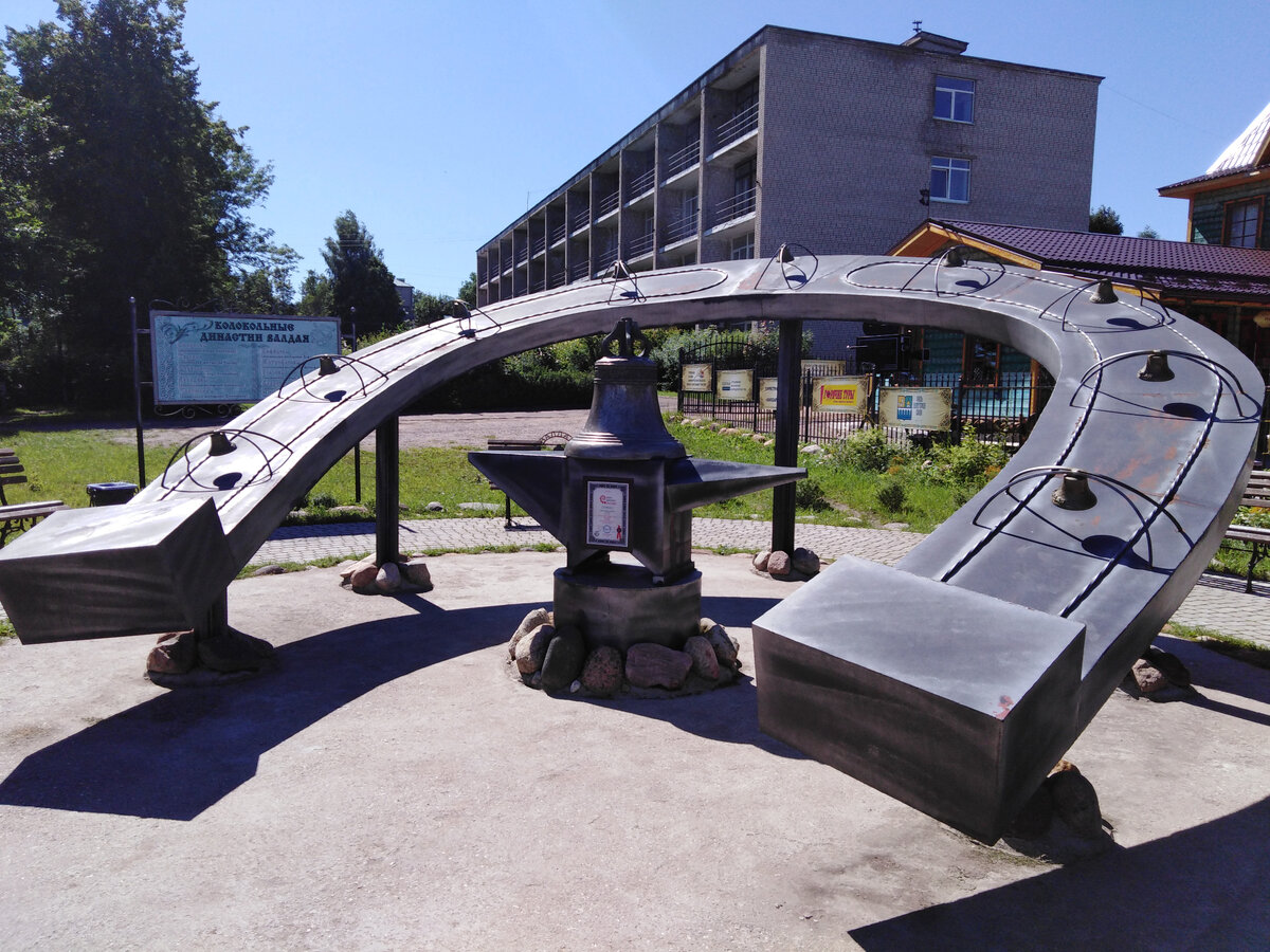 На заднем плане слева вы можете увидеть стенд. На нем показаны колокольные династии Валдая. Данный памятник расположен на центральной улице города.