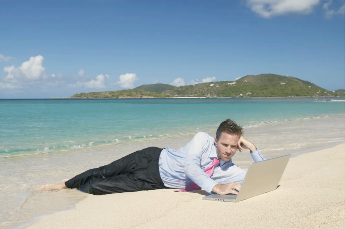 Человек отдыхает. С ноутом на пляже. Человек с ноутбуком на море. Отпуск.