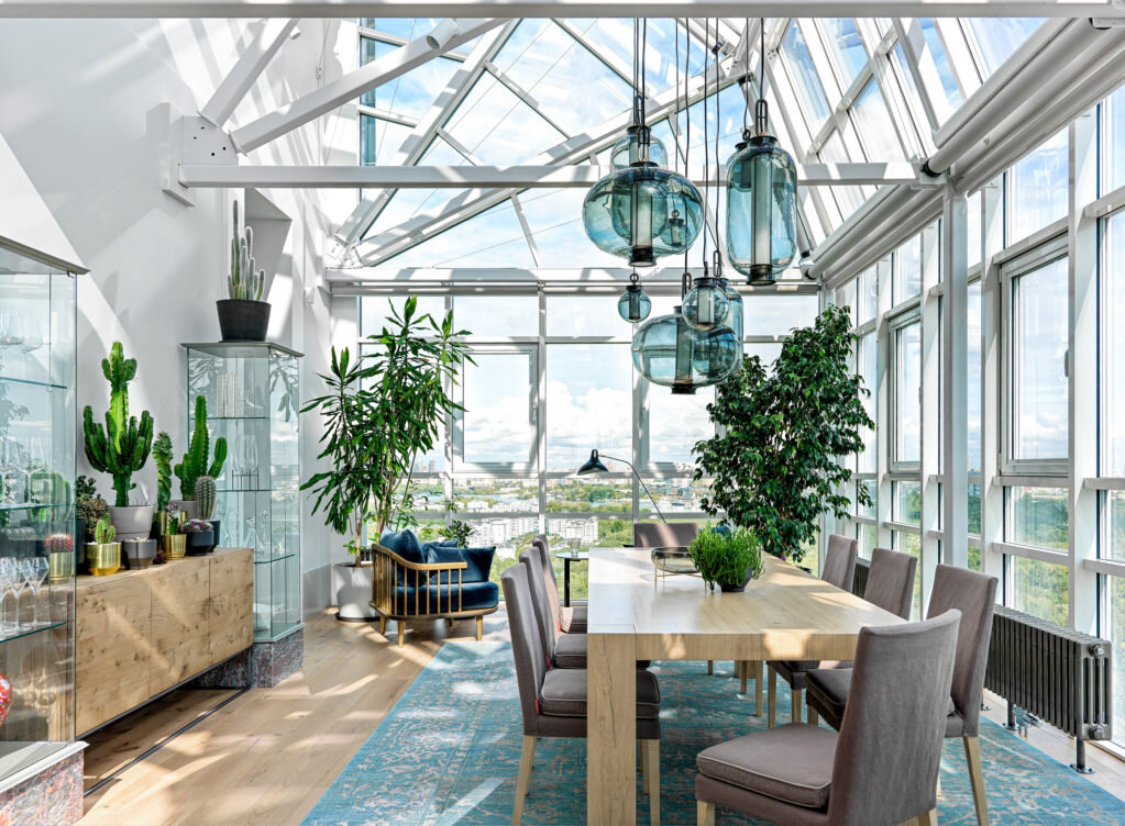 Обеденный стол, Van Rossum, в окружении стульев, Flexform; кресла, &Tradition; журнальный столик, De Padova; комод, Form Exclusiv; витрины, Cattelan Italia; подвесной светильник, Parachilna; торшер, DCW Éditions.