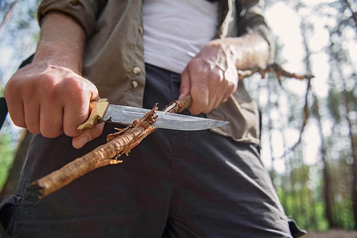 Рубить ветку. Нож в лесу. Турист с ножом в лесу. Нож для похода в лес. Нож палка.