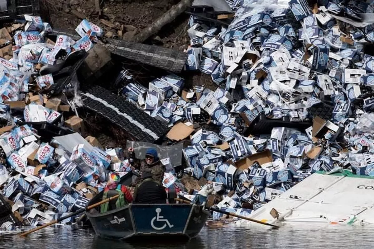 Джим Лапотка держит бутылку пива, найденную в воскресенье после крушения поезда на реке Кларк-​Форк к северу от Куиннс-​Хот-Спрингс и шоссе 135 

