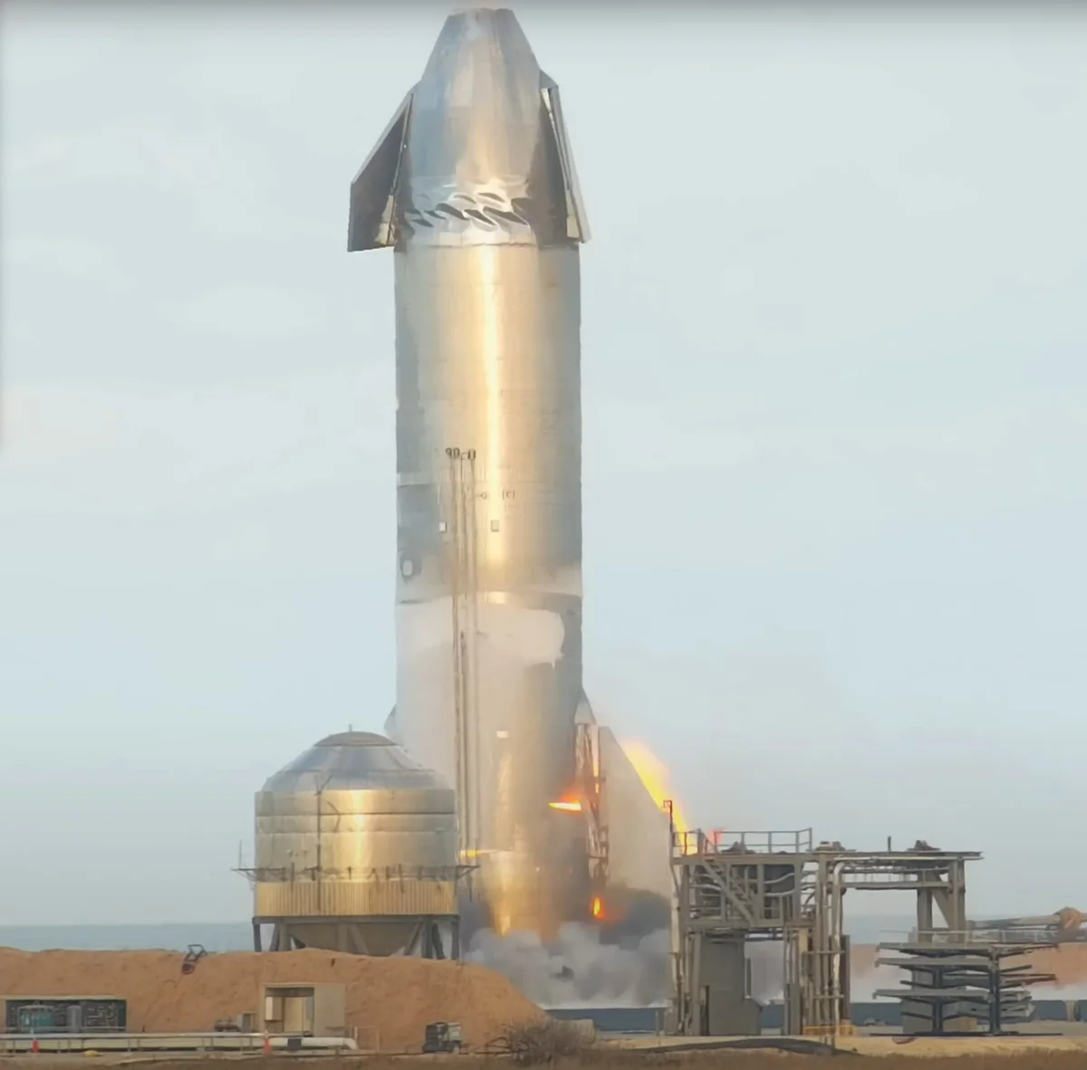 Starship SN10 буквально за секунду до взрыва — видно пламя, вырывающееся из трещины в корпусе.