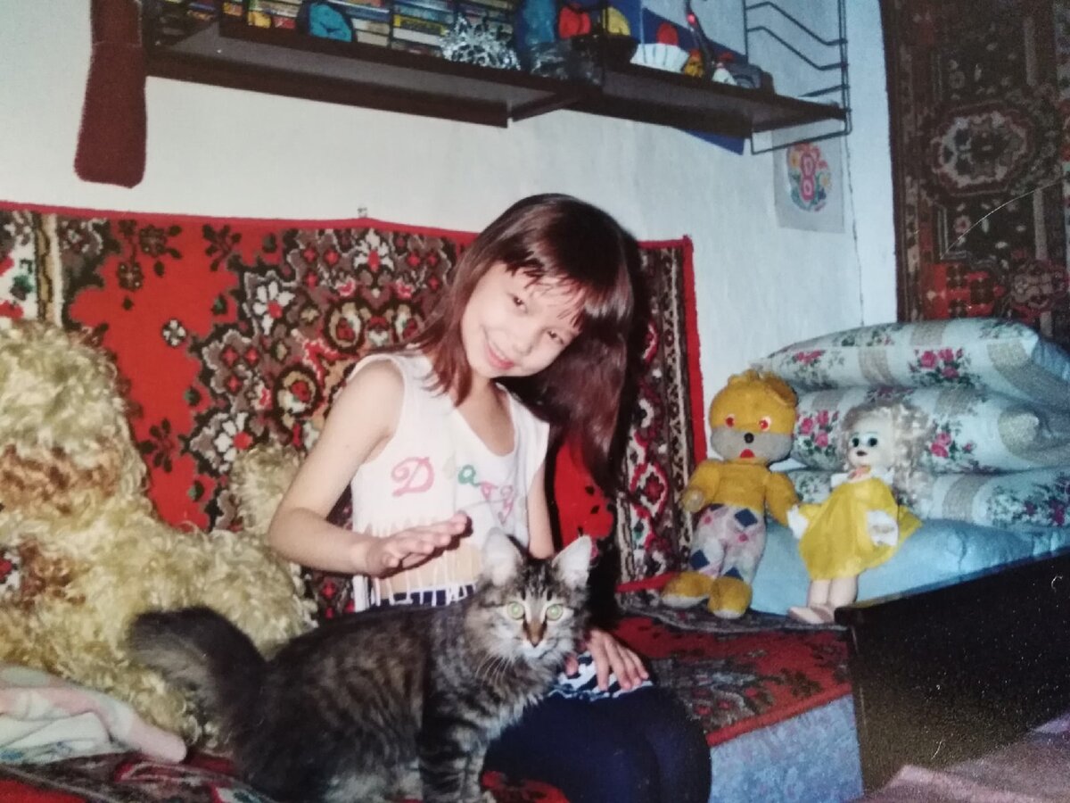 Пятилетняя я с кошкой Сабриной. С правой стороны фотографии можно заметить ту самую куклу Кристину, правда уже с разукрашенным в зеленый цвет лицом