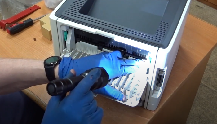 Фото 4. Посветив фонариком внутрь, видим, что изношена термопленка, а также внутри аппарата валяются куски резинового вала