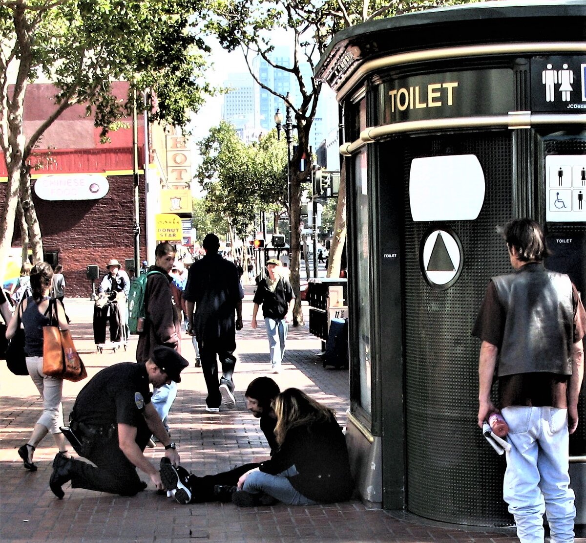 а говорят копы злые? полицейский на коленях перед  бомжами в Сан Франциско