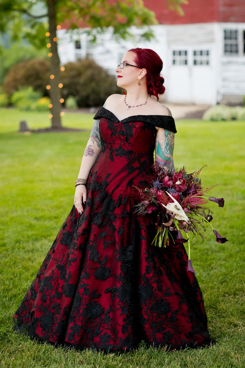 Elizabeth Arasevi wore a custom-made red gown with black lace at her June 2021 wedding. “Stuffing myself into a sugary sweet white dress for the sake of tradition was not an option,” she said.