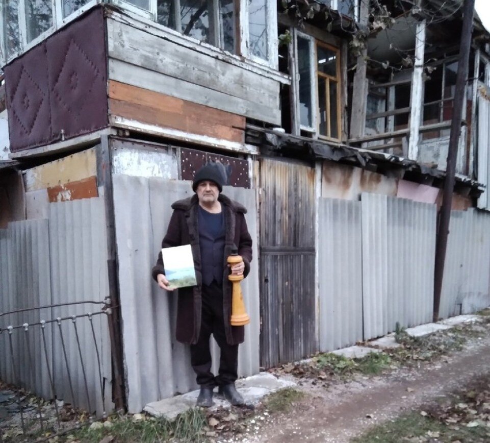 В руках у Ришата шахматная пешка, а за спиной тот самый дом