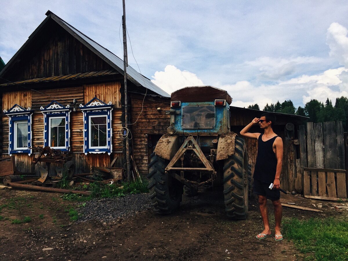 Чисто деревенский стиль: избушка расписная с узорными ставнями и трактор