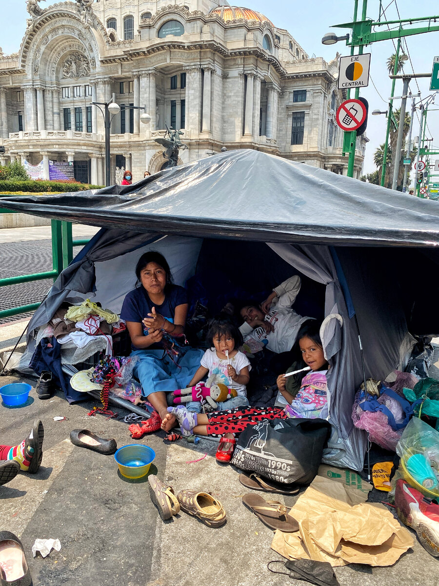 Целая семья индейцев в палатке на фоне главного музея страны.