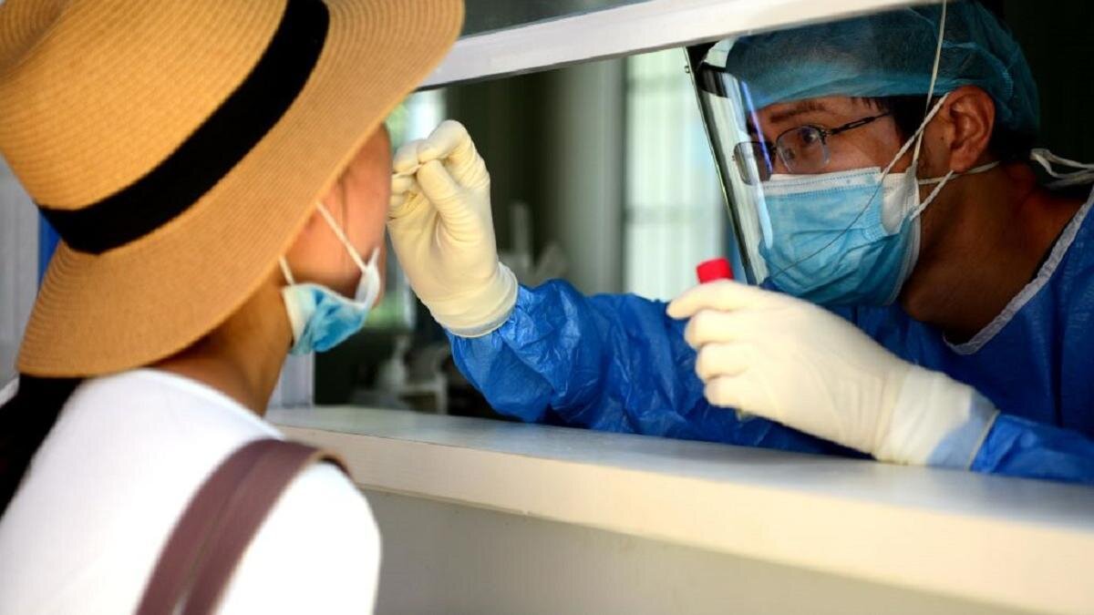    Девушки в шляпе сдает анализ на КВИ:Wang Dongming/China News Service via Getty Images