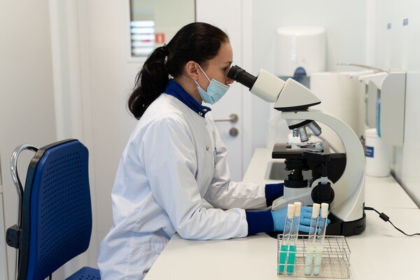 просто девушка за микроскопом. Для иллюстрации