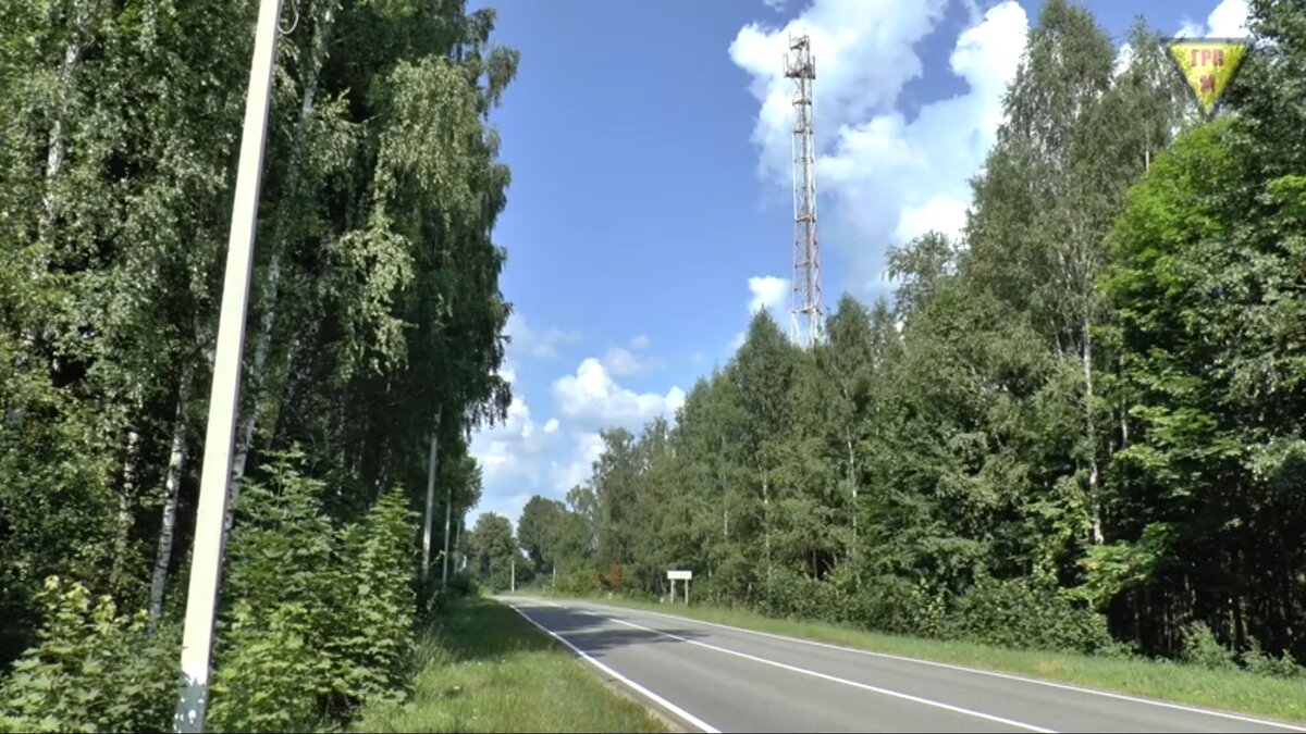 Антенна сотового оператора и табличка с названием села при въезде.