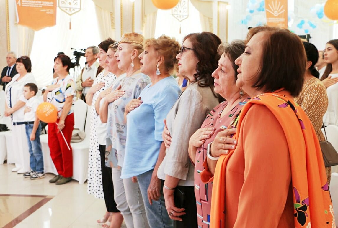 Посетители ярмарки во время исполнения национального гимна крымскотатарского народа Добавьте описание
