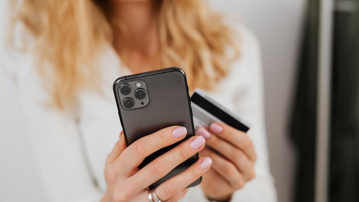    Девушка держит смартфон и банковскую карту:pexels.com