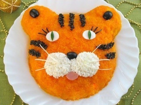  🐯 Салат "Тигренок"
Ингредиенты: картофель - 400 гр, вареная колбаса - 200 гр, огурцы - 200 гр, лук-порей или репчатый лук - 150 гр, яйца - 3 шт, морковь - 400 гр, майонез, соль, маслины (для украшения).
Готовим: Картофель и морковь отвариваем до готовности, остужаем, чистим. Картофель и морковь натираем на мелкой терке. Колбасу и огурцы нарезаем мелкими кубиками. Лук-порей мелко крошим (репчатый лук нарезаем кубиками, заливаем кипятком, оставляем на 15 минут, затем промываем в холодной воде). Яйца варим вкрутую, остужаем, чистим и натираем на мелкой терке (белок от одного яйца оставляем для украшения).
На дно плоского блюда выкладываем картофель, придаем форму головы тигра и смываем майонезом. На картофель выкладываем слоями, смазывая каждый слой майонезом и подсаливая, следующие ингредиенты: вареная колбаса, огурцы, лук, яйца. Последним слоем выкладываем морковь, покрывая весь салат.
Из яичного белка делаем глазки и щечки тигренка. Мелко нарезаем около 6-7 маслин. Делаем из них нос и ресницы. Из огурца - зрачки. Из колбасы - рот. Из оставшихся нарезанных маслин выкладываем полоски. Усы можно сделать из белой части лука порея.
Приятного аппетита!