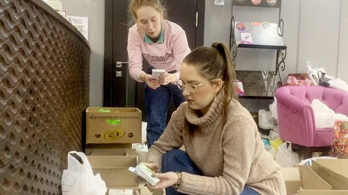 Волонтеры пункта сбора гуманитарной помощи в Донецке Александра Петрова (на переднем плане) и Анастасия Огородник сортируют по коробкам лекарства, вещи и продукты для защитников ДНР и мирных жителей / Фото: Алексей Зернаков / Вечерняя Москва