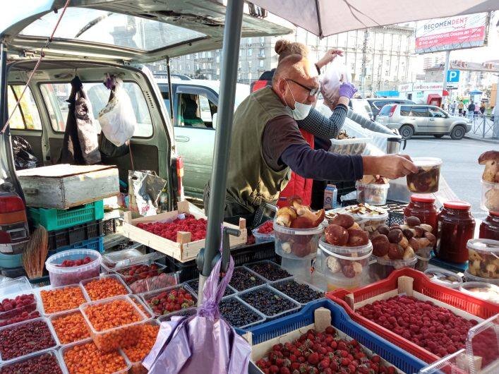 
Очередям все равно, что они поставят на свой стол продукт прямиком с улицы. Наспех сколоченный деревянный прилавок, разбросанный гниющий мусор, лежащие вперемешку овощи и фрукты, которые до этого доставали из прицепа какой-нибудь «ГАЗели», чтобы теперь ими пировали птицы — так выглядит обычная лавка уличного торговца-нелегала в Новосибирске. Картина малоприятная, но для нашего потребителя недостаточно убедительная: глаза боятся, а руки так и тянутся к кошельку.