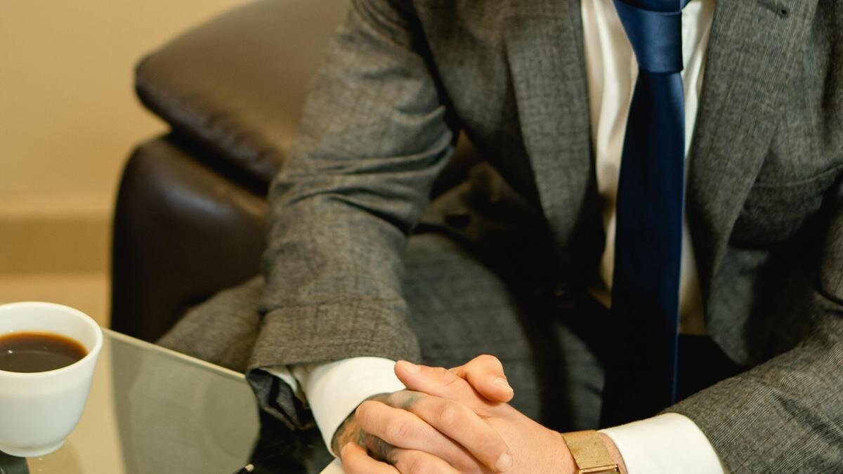    Мужчина в костюме сидит за столом:pexels.com