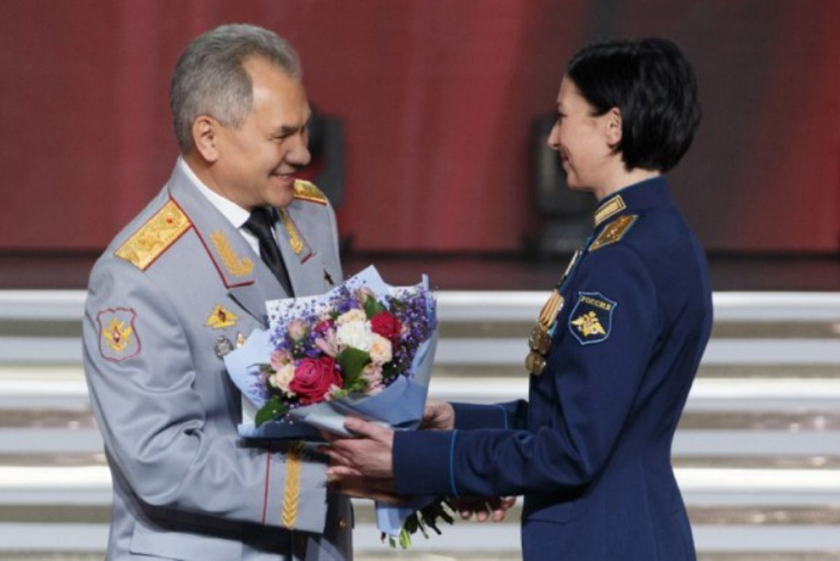 Фото от пресс-службы Минобороны РФ. Министр обороны России награждает женщину офицера ведомственной наградой.
