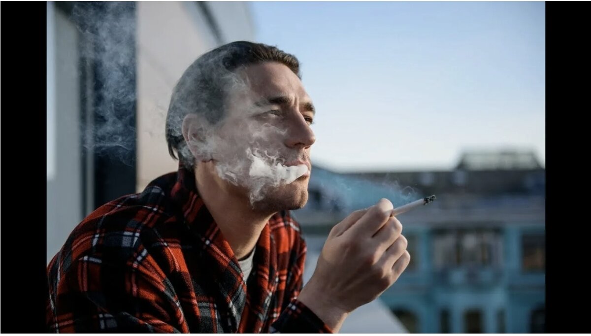 Мужчина курит на балконе