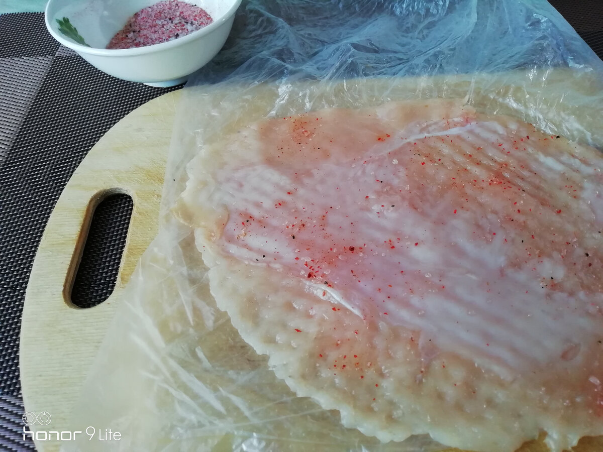 Когда все филешки разрезаны, я кладу на разделочную доску полиэтиленовый пакет, на одну его сторону кладу пласт филешки, другой стороной накрываю и отбиваю деревянным молоточком,не сильно, чтобы не порвать филешки. Солю, перчу с каждой стороны по чуть - чуть.